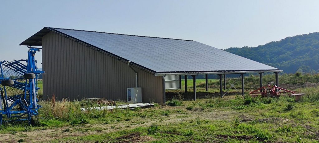 hangar agricole avec centrale solaire en toiture vu de trois quarts dos