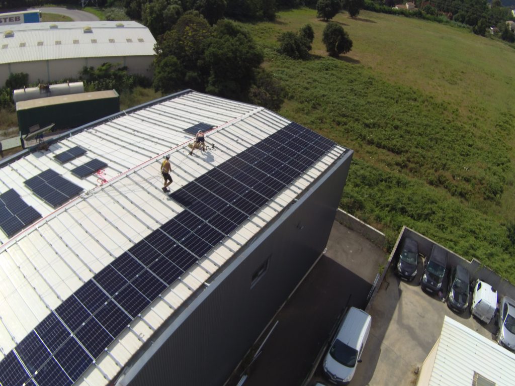 des techniciens installent des panneaux solaires sur une toiture