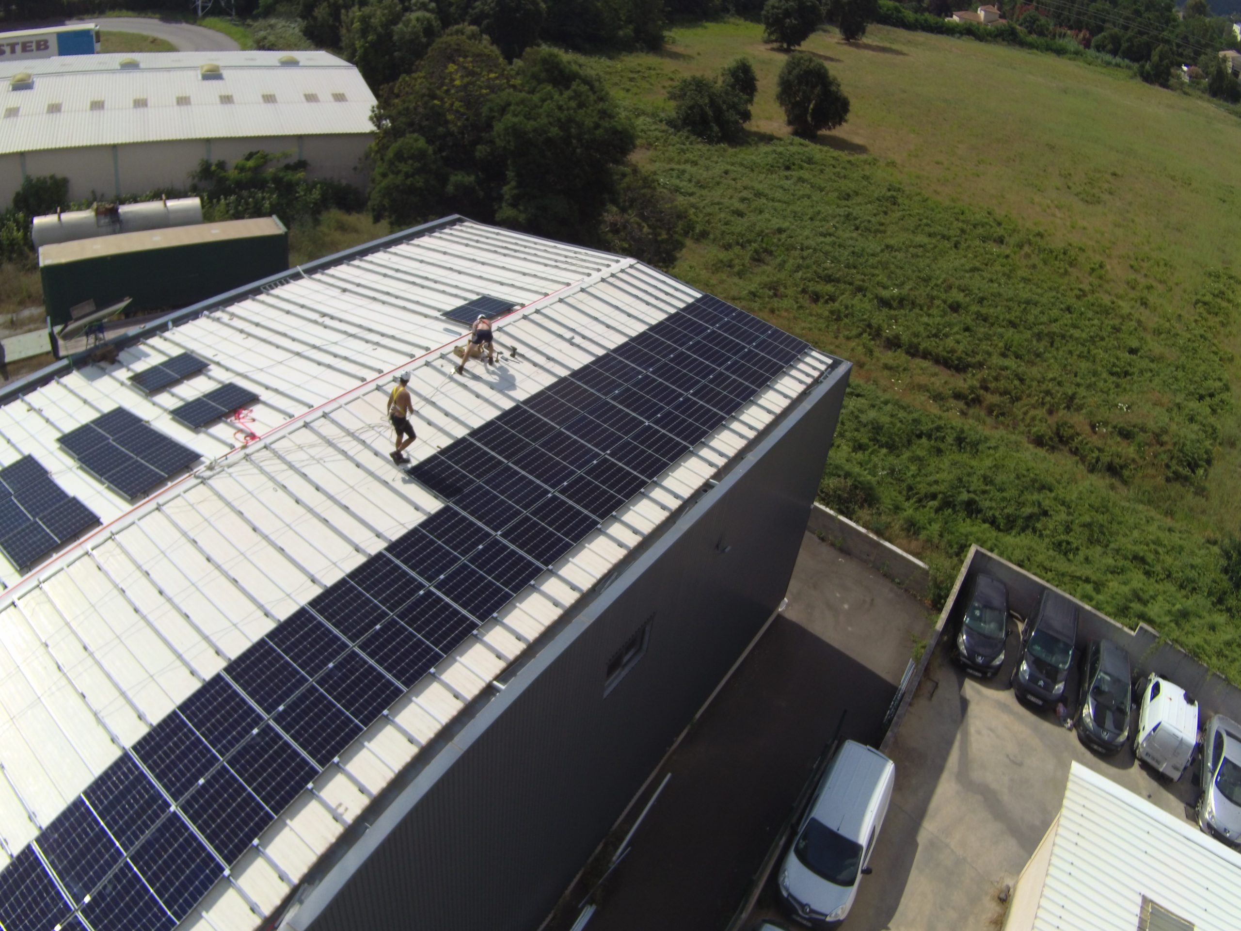des techniciens installent des panneaux solaires sur une toiture