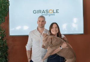 Pierre-Marie Berlingeri, Juliette Marti et la mascotte Vega de Girasole Energies posent ensemble devant un écran affichant le logo de l’entreprise.